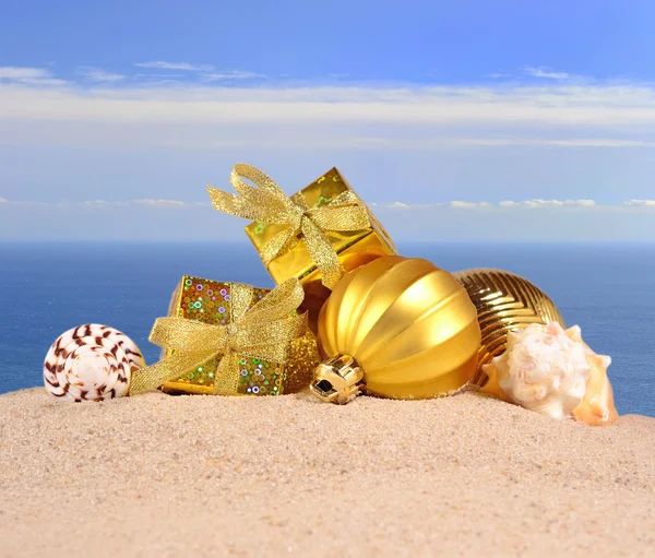 Ozdoby świąteczne i muszle na plaży piasek — Zdjęcie stockowe