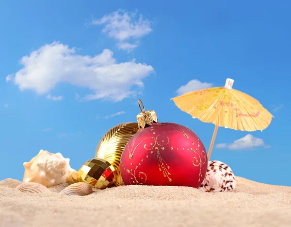 圣诞装饰品和沙海滩上的贝壳 免版税图库图片