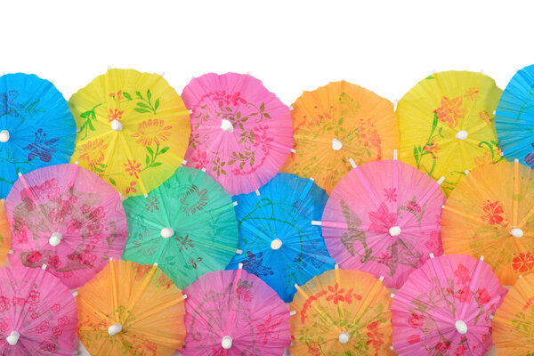 Цветные бумажные коктейльные зонтики крупным планом на белом фоне
 