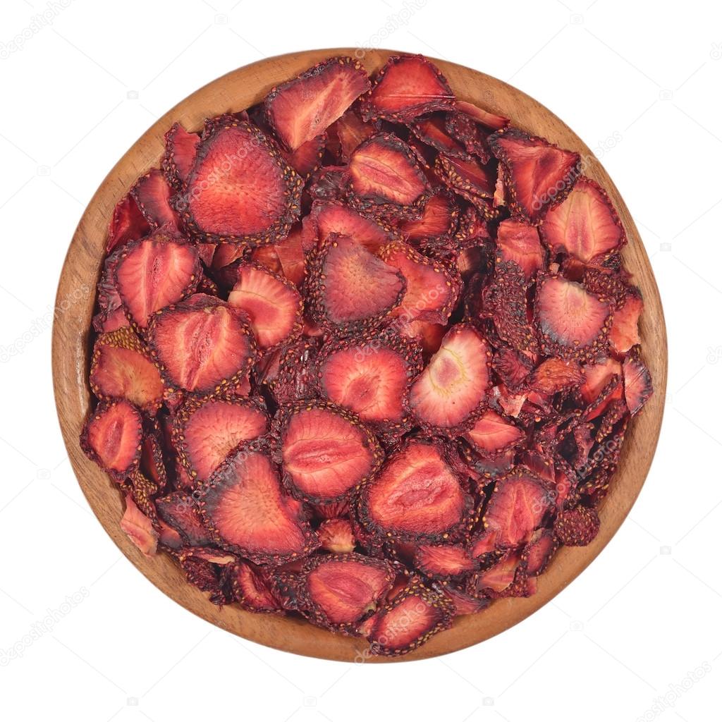 Dried strawberries in a wooden bowl on a white