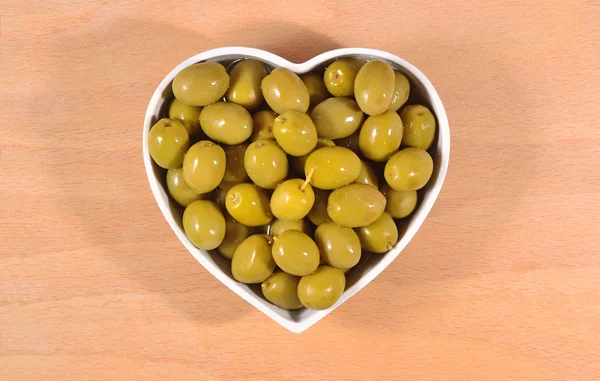 Aceitunas verdes en plato en forma de corazón —  Fotos de Stock