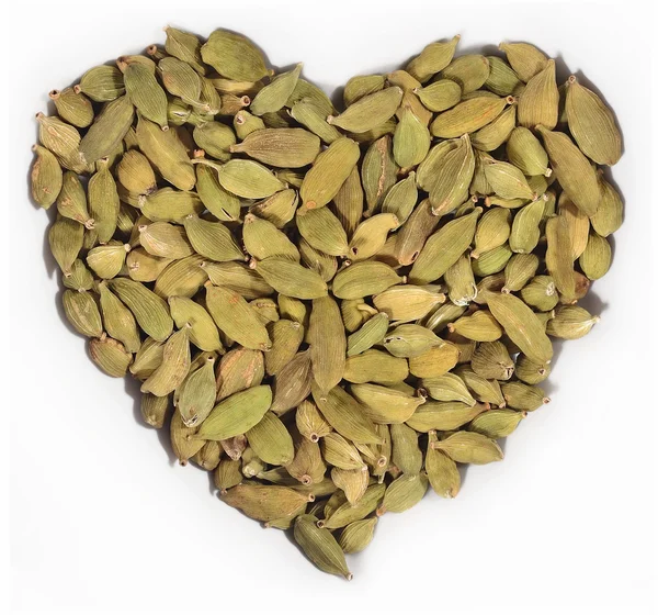 Cardamom seeds in the form of heart on a white — Stock Photo, Image