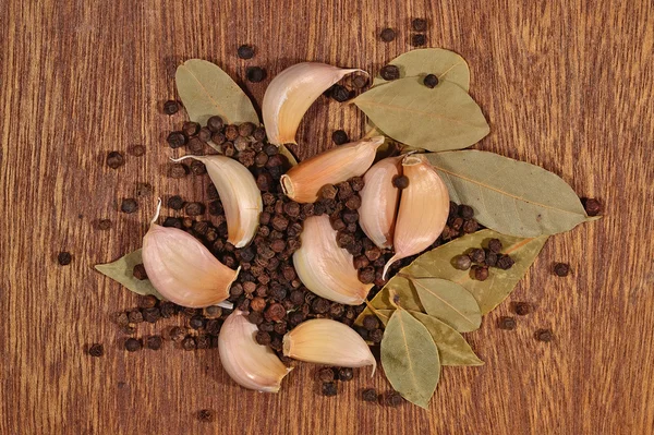 Heap of garlic, bay leaves and peppercorns — Stock Photo, Image