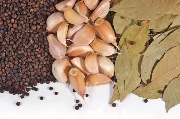 Garlic, bay leaves and peppercorns on a white — Stock Photo, Image