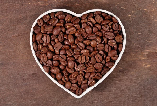 Kávová zrna v desce v podobě srdce — Stock fotografie