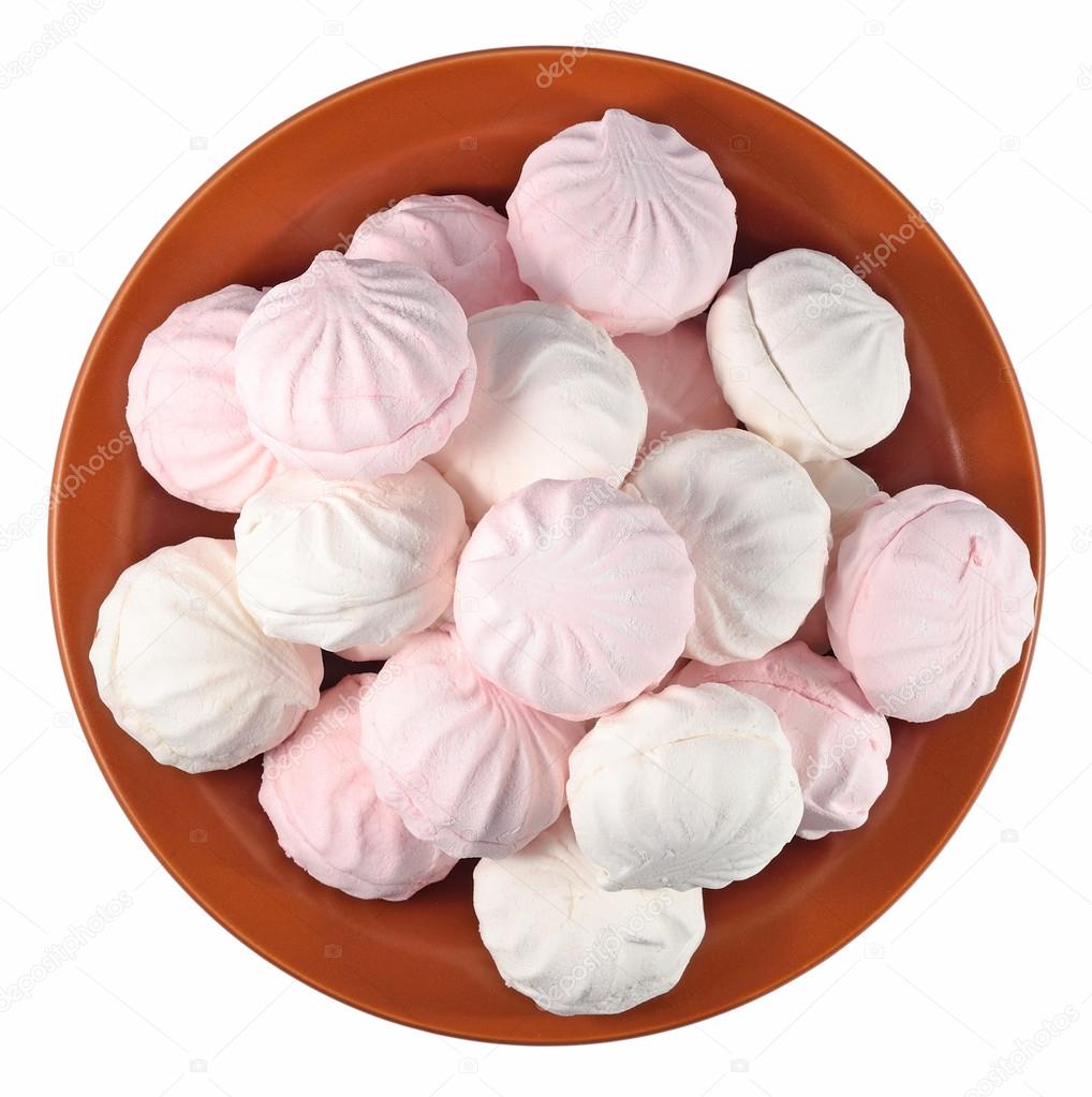 White and pink marshmallow on a ceramic plate on a white