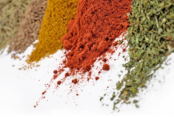 Heaps of different dry spices on a white — Stock Photo, Image