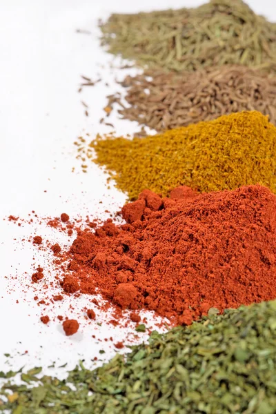Heaps of different dry spices on a white — Stock Photo, Image