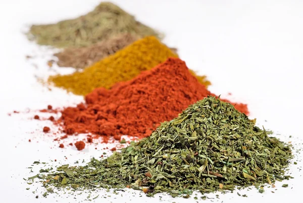Heaps of different dry spices on a white Stock Picture