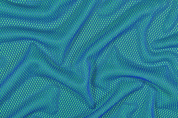 Blue crumpled nonwoven fabric on a green — Stock Photo, Image