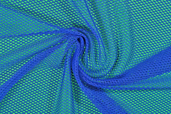 Blue crumpled nonwoven fabric on a green — Stock Photo, Image