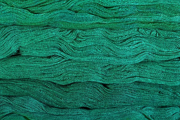 Green skeins of floss as background texture — Stock Photo, Image