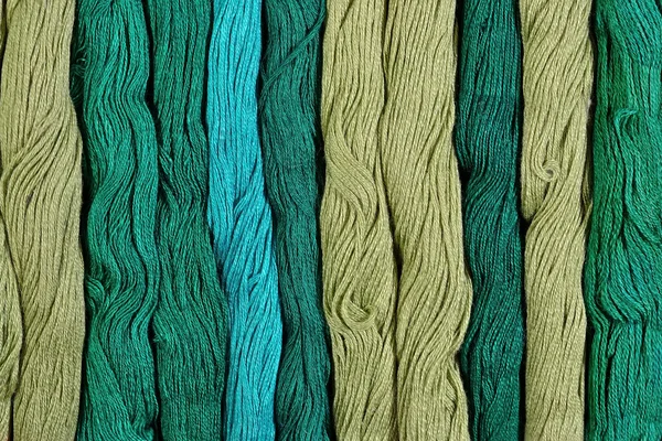 Green skeins of floss as background texture — Stock Photo, Image