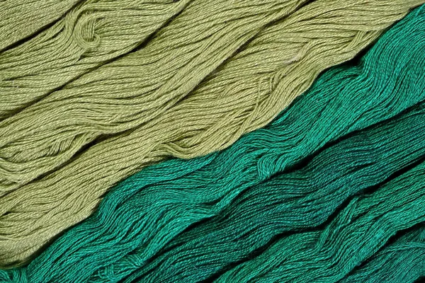 Green skeins of floss as background texture — Stock Photo, Image