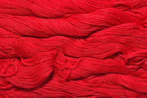 Red skeins of floss as background texture — Stock Photo, Image