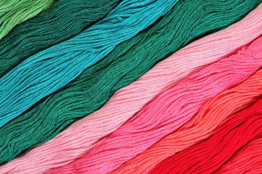 Colorful skeins of floss as background texture clipart