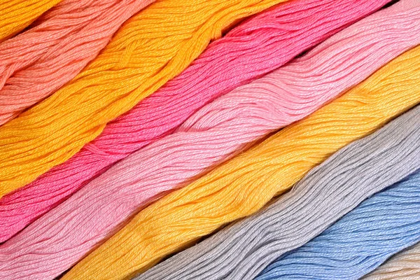 Colorful skeins of floss as background texture — Stock Photo, Image