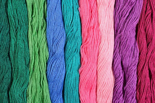 Colorful skeins of floss as background texture — Stock Photo, Image