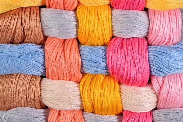 Colorful twisted skeins of floss as background texture — Stock Photo, Image