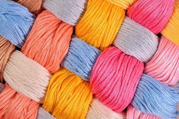 Colorful twisted skeins of floss as background texture — Stock Photo, Image