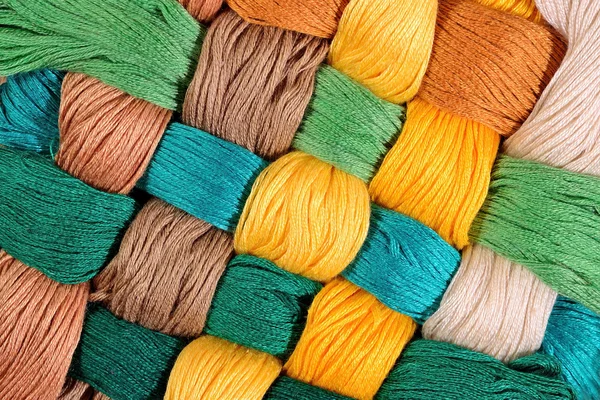 Colorful twisted skeins of floss as background texture — Stock Photo, Image