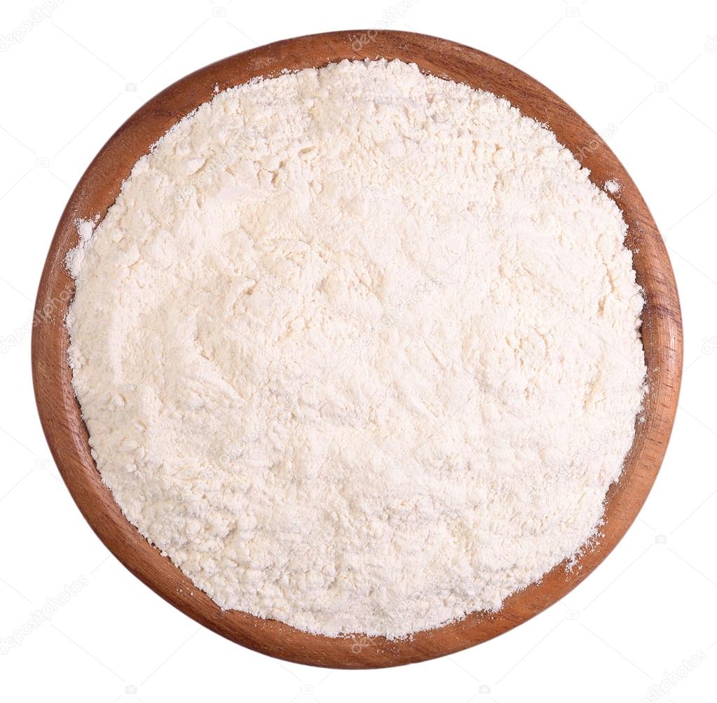 White flour in a wooden bowl on a white