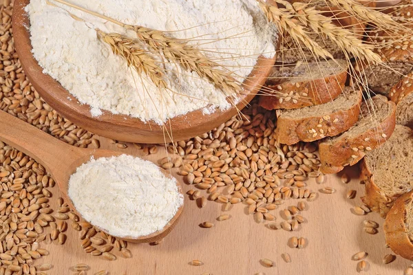 Farine blanche dans une cuillère en bois, blé et pain — Photo