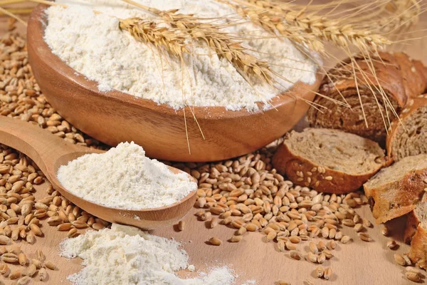 Beyaz un bir tahta kaşık, buğday ve ekmek 