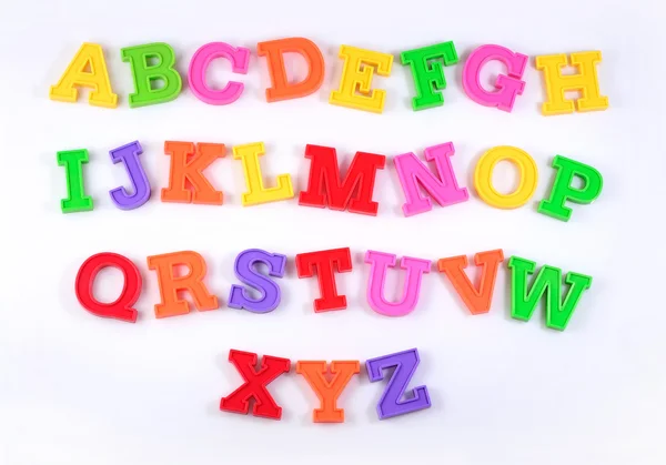 Цветные пластиковые буквы алфавита на белом — стоковое фото
