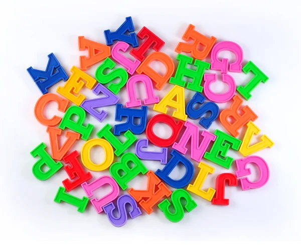 Heap of plastic colorful alphabet letters on a white — Stock Photo, Image