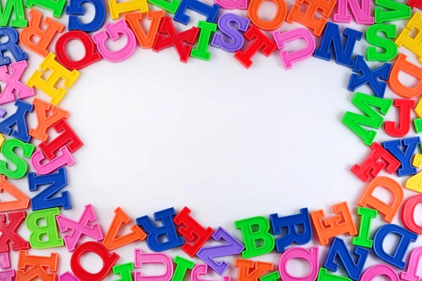 Quadro de letras coloridas de plástico alfabeto em um branco — Fotografia de Stock