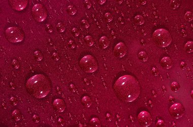 Kırmızı yüzeyde su damlaları 