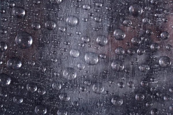 Wassertropfen auf der zerkratzten Oberfläche — Stockfoto