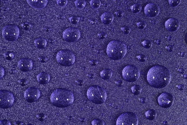 Water drops on the violet surface. Selective focus. — Stock Photo, Image