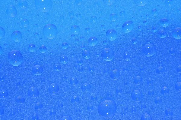Waterdruppels op blauwe achtergrond — Stockfoto