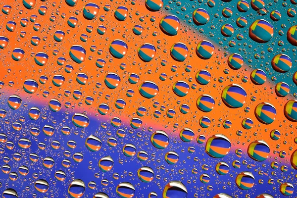 Gotas de água no fundo multicolor — Fotografia de Stock