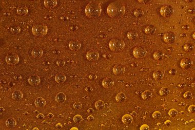 Kahverengi yüzeyinde su damlaları