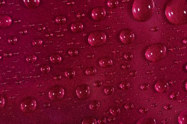 Su kırmızı zemin üzerine bırakır. Seçici odak.