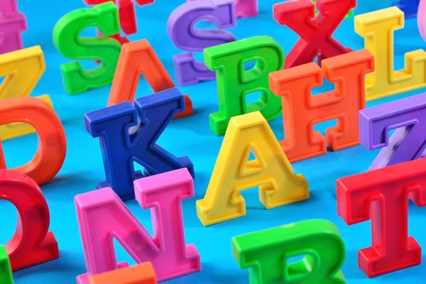Plastica lettere alfabeto colorato da vicino su un blu — Foto Stock