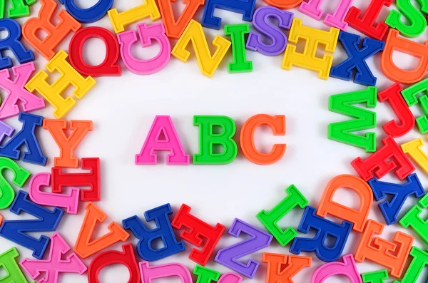 Lettere alfabetiche colorate in plastica ABC su un bianco — Foto Stock