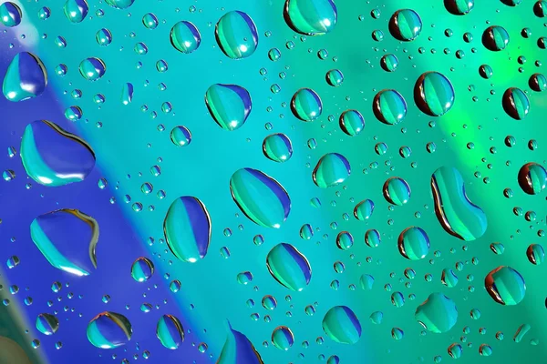 Вода падає на кольоровий фон — стокове фото