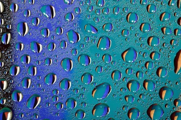 Kapky vody na barevném pozadí — Stock fotografie