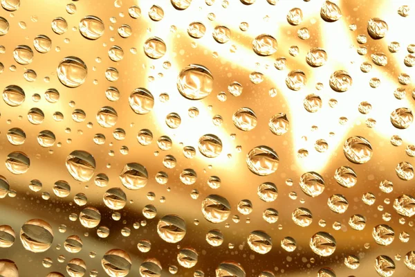 Gotas de agua en la superficie dorada — Foto de Stock