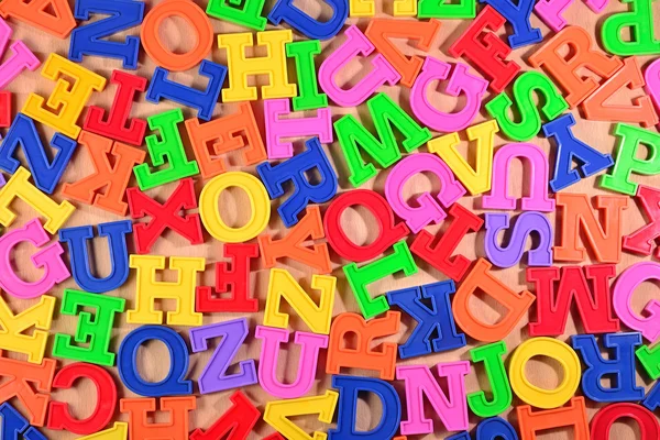 Барвисті пластикові літери алфавіту як фон — стокове фото