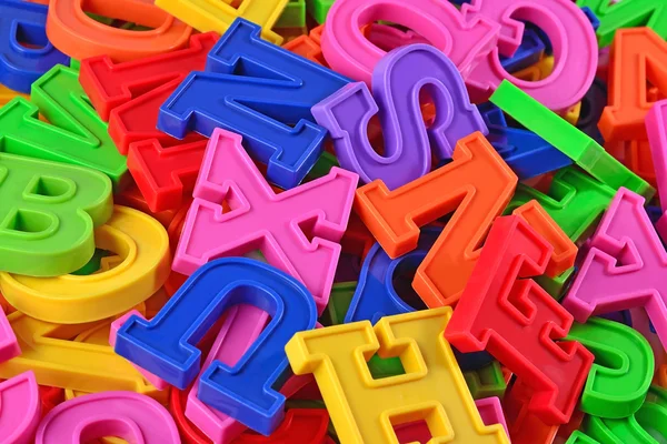 Heap of plastic colored alphabet letters close up — Stock Photo, Image