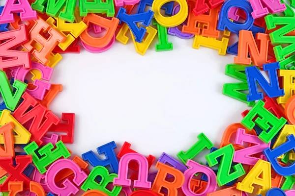 Marco de letras de alfabeto colorido plástico en un blanco —  Fotos de Stock
