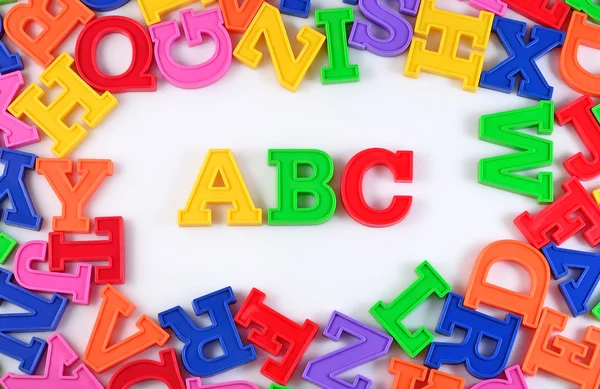 Lettere alfabetiche colorate in plastica ABC su un bianco — Foto Stock