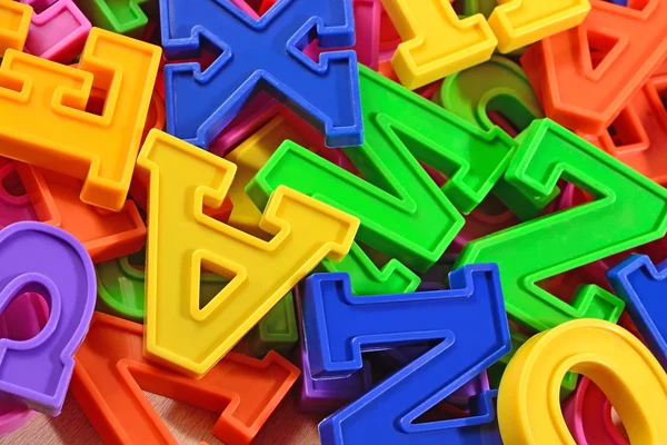 Heap of plastic colored alphabet letters close up — Stock Photo, Image