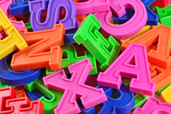 Montón de letras de alfabeto de plástico de color de cerca — Foto de Stock