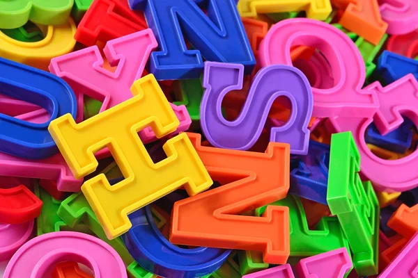 Heap of plastic colored alphabet letters close up — Stock Photo, Image